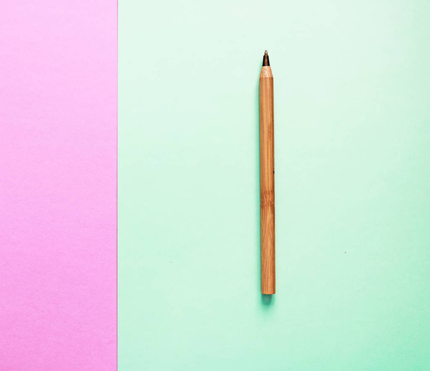 Brown újrahasznosított öko toll két háttérrel: rózsaszín és zöld. Lapos feküdt. Hely a szöveghez. Öko-és választási koncepció - Fotó, kép