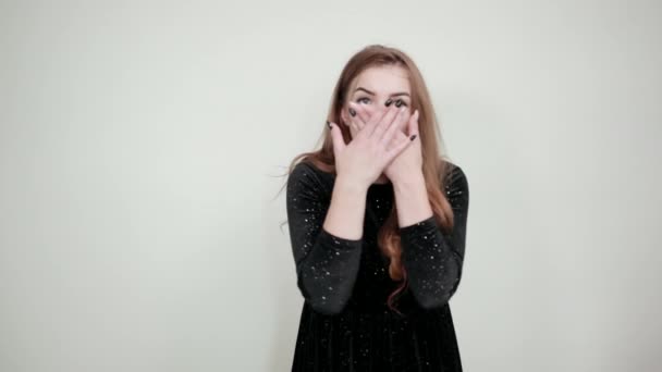 dívka hnědá v černých šatech přes izolované bílé pozadí vykazuje emoce - Záběry, video