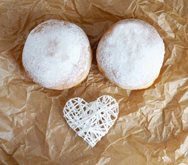 Cukros fánk díszített fehér szív felülnézetben, vicces élelmiszer koncepció - Fotó, kép