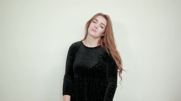 Девушка каштановые волосы в черном платье на изолированном белом фоне показывает эмоции
 - Кадры, видео