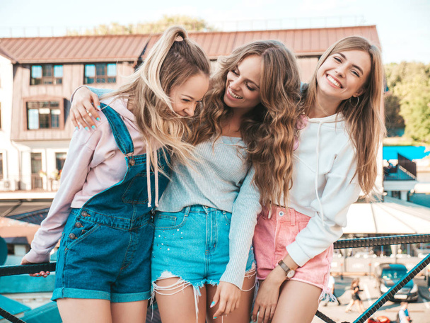 Portrait of three young beautiful smiling hipster girls in trendy summer clothes. Sexy carefree women posing on the street background.Positive models having fun - Фото, зображення