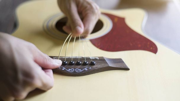 Cambiar las cuerdas de guitarra acústica
 - Foto, imagen