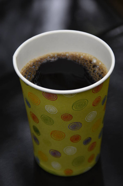 Vue du dessus d'une tasse en papier de café brassé noir sur une table en bois
 - Photo, image