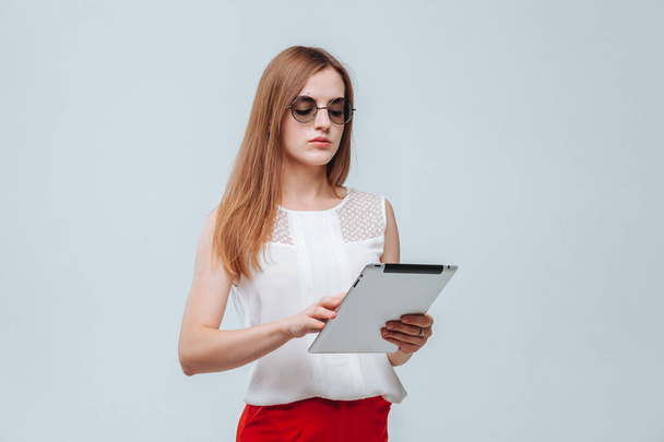 Mädchen arbeitet an einem Tablet auf hellem Hintergrund - Foto, Bild