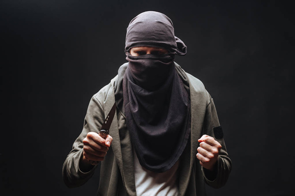  злочинець у масці загрожує ножем темний фон
 - Фото, зображення