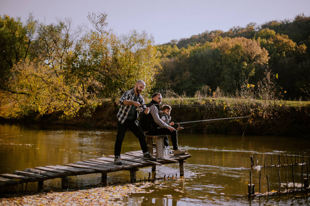 Beautiful place at nature amazing lake , two men and one litt boy fishing together - Foto, Imagem