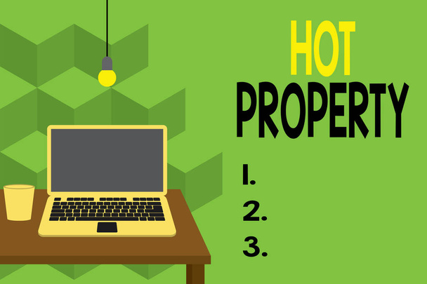 Text sign showing Hot Property. Conceptual photo Something which is sought after or is Heavily Deanalysisded Front view open laptop lying on wooden desktop light bulb falling glass. - Photo, Image