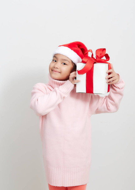 Девушка с подарочной коробкой в свитере и шляпе Санты
 - Фото, изображение
