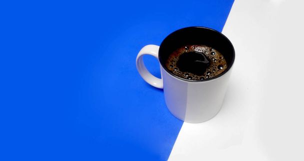 Kaffeetasse auf weißem und blauem Hintergrund, eingeschaltet, Konzept - Foto, Bild
