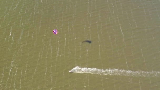 Kitesurfers jeździć na falach w lecie na morzu w wietrznej pogodzie - Materiał filmowy, wideo