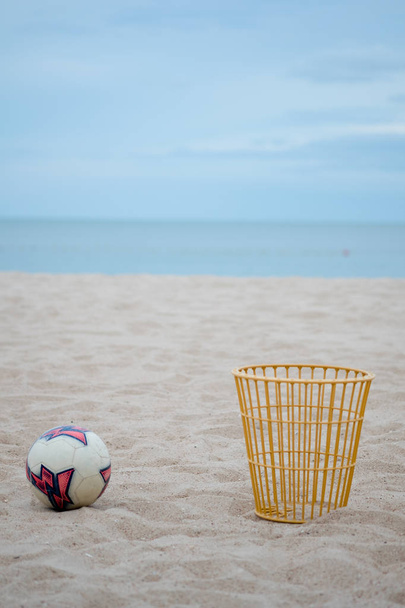 Bal en houten mand zetten op het strand.  - Foto, afbeelding