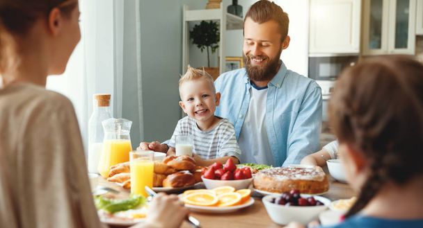 familia madre padre e hijos tienen desayuno en la cocina en m
 - Foto, Imagen