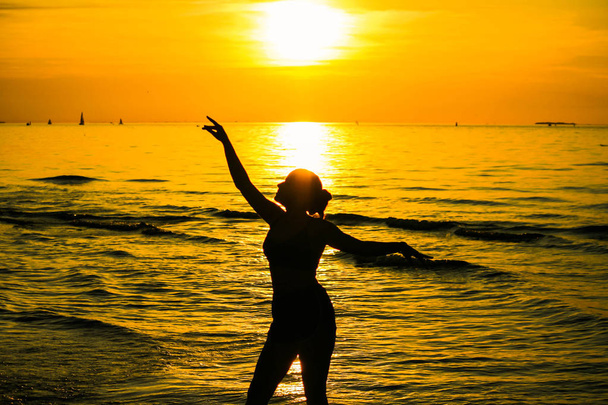 Girls silhouette during sunset on the sea - Фото, зображення
