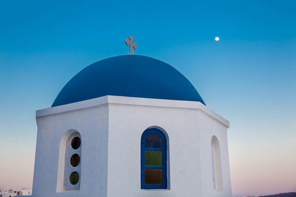 Traditionele koepel van de kerken in de stad Oia en de maan op het eiland Santorini - Foto, afbeelding