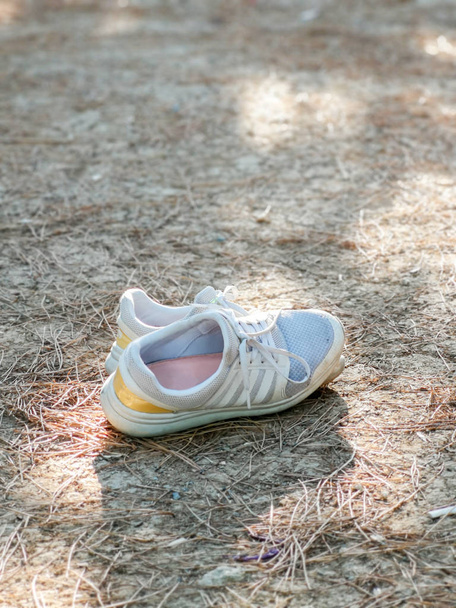 Zapatillas viejas en suelo seco
 - Foto, imagen