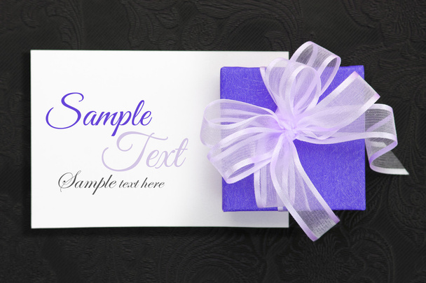 Violetti lahjapakkaus nauha valkoisella kortilla
 - Valokuva, kuva