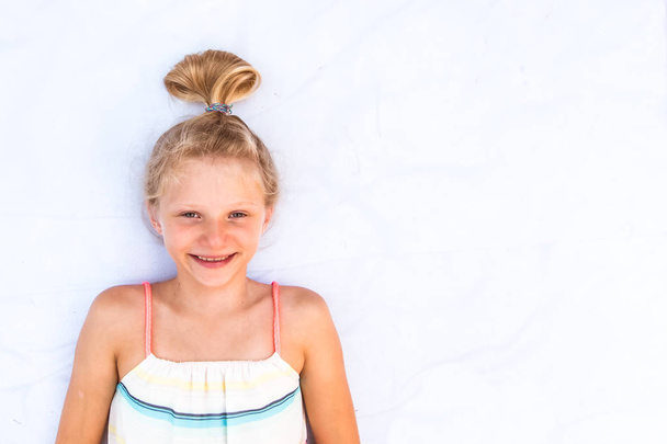 charming smiling young child with blond bun copy space  - Photo, Image