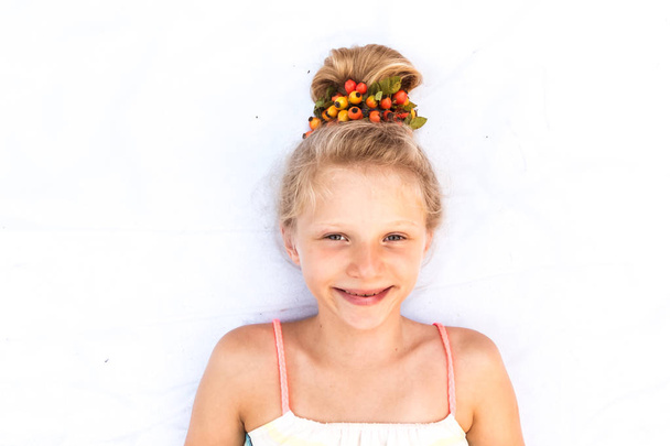 aranyos mosolygós kis gyermek vicces szőke zsemle díszített piros brier bogyó másolás hely  - Fotó, kép