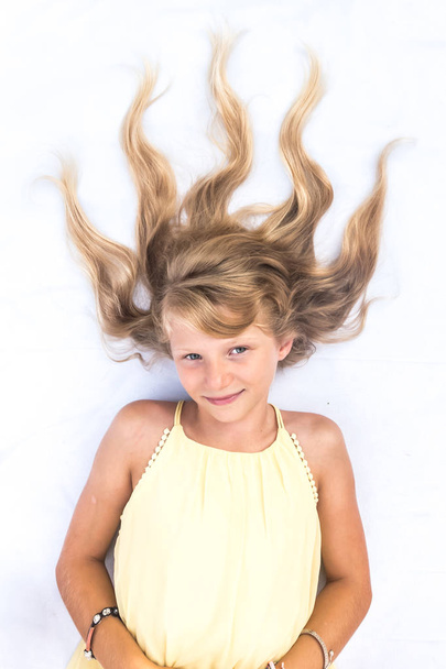 чарівна усміхнена дитина зі здоровим і міцним довгим світлим волоссям у формі вогняного копіювання простору
 - Фото, зображення
