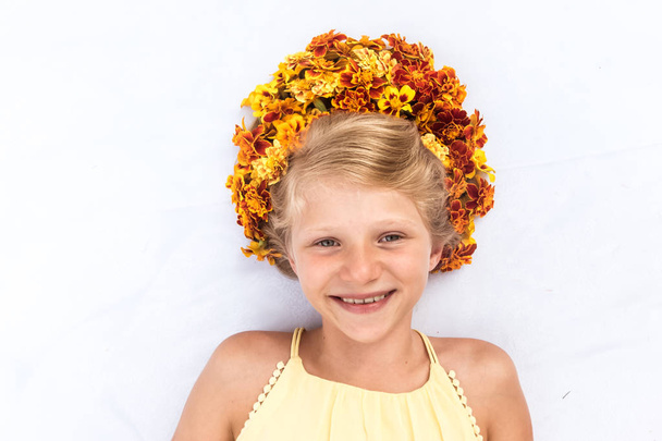charmant enfant souriant avec des cheveux ornés d'un bandeau floral - Photo, image
