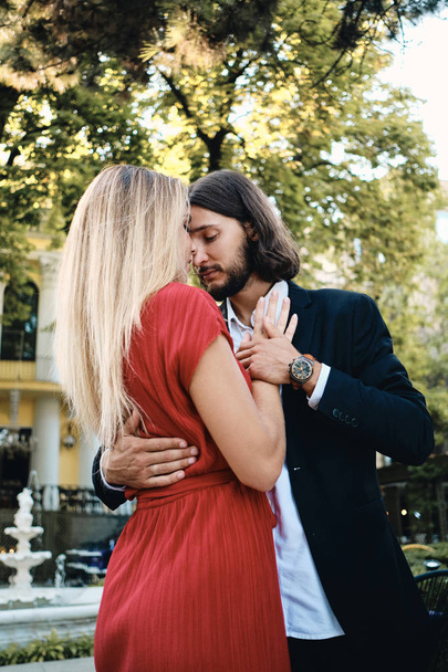 若い美しいロマンチックなカップルは、レストランの居心地の良い庭でデートに感覚的に踊ります - 写真・画像