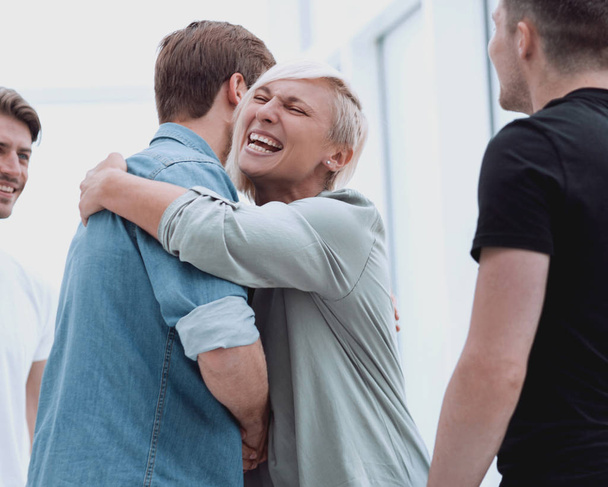 happy coworkers hugging each other when meeting - Foto, Bild