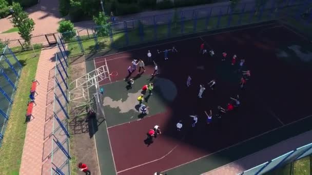 Εναέρια θέα παιδιά εκπαίδευση αθλητικό μάθημα στο γήπεδο μπάσκετ στο σχολικό προαύλιο - Πλάνα, βίντεο