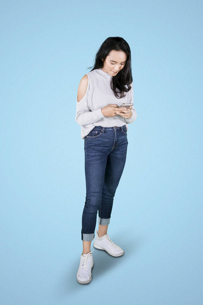 Young woman texting on a mobile phone - Fotó, kép