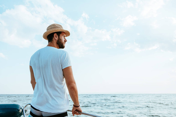 Молодий чоловік насолоджується видом на море з човна
 - Фото, зображення