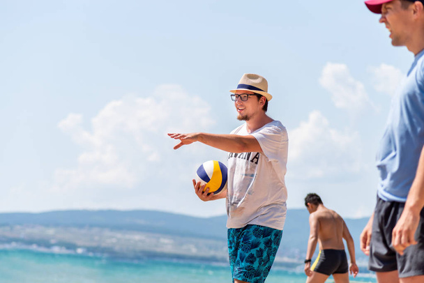 Genç fit kafkas erkekler bir takımda plaj voleybolu oynuyor - Fotoğraf, Görsel