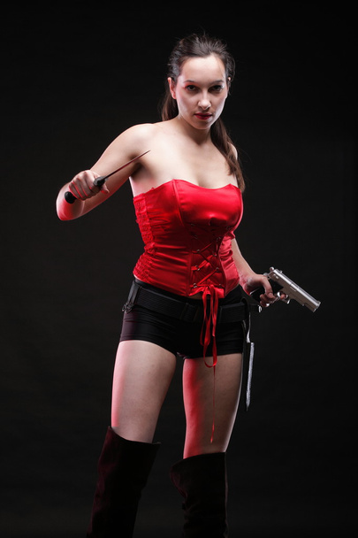 Sexy young woman - gun on black background - Fotó, kép