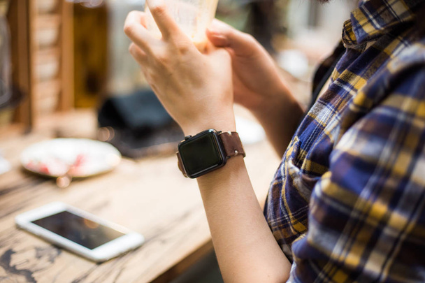 Women hand wear smart watch sitting in cafe - 写真・画像