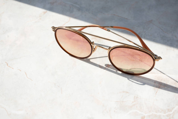 Schicke Sonnenbrille für Frauen auf hellem Marmorhintergrund in Naturfarben - Foto, Bild
