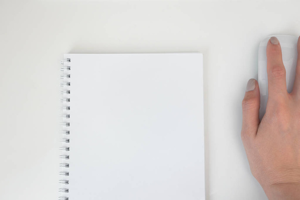 Білий порожній паперовий спіральний блокнот і жіноча рука на комп'ютері mo
 - Фото, зображення