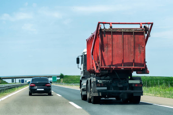 Camión de basura en una carretera rural o autopista con tráfico ligero
 - Foto, imagen