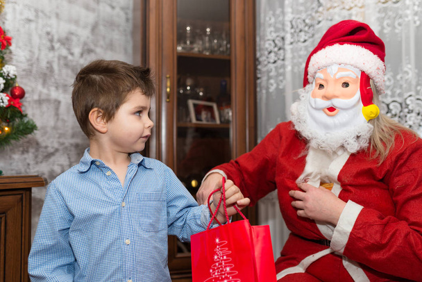 Nieśmiałe dziecko kilka lat otrzymuje prezent od Świętego Mikołaja. - Zdjęcie, obraz