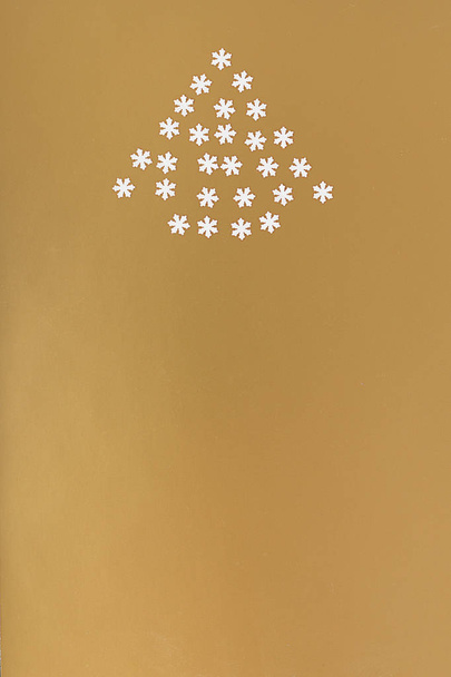 Christmas tree of snowflakes on a gold background. New year conc - Foto, Imagem