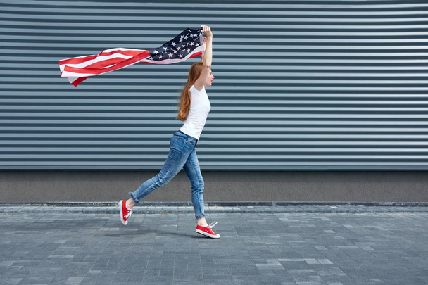 День независимости и патриотическая концепция. Молодая рыжая женщина с
 - Фото, изображение