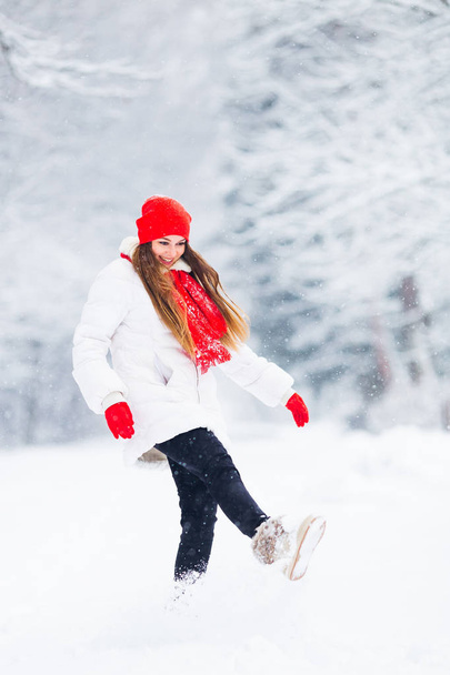 Het meisje in een winterjasje en warme accessoires hebben plezier in een s - Foto, afbeelding