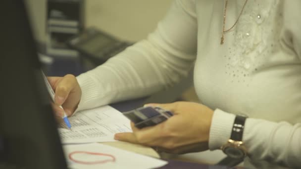 nainen allekirjoittaa asiakirjat käsin
 - Materiaali, video