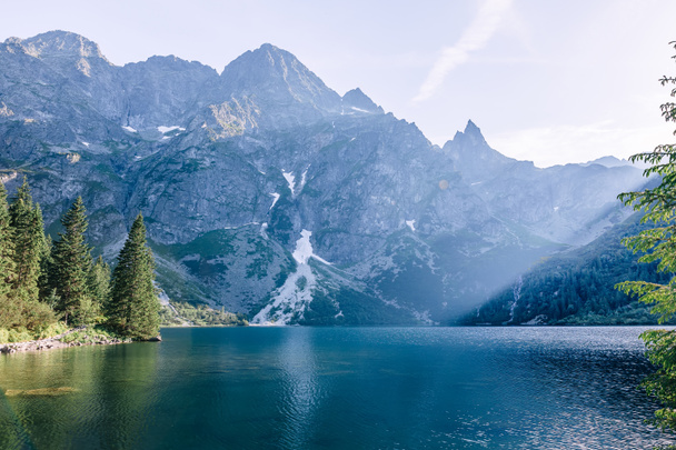  青い水と山の中で湖。山の岩の山. - 写真・画像