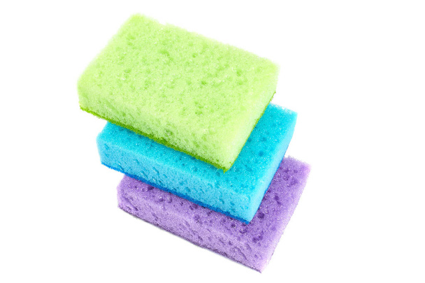 Éponges de couleur vive pour le nettoyage de la salle de bains, le lavage de la vaisselle et d'autres besoins domestiques sont situés en diagonale l'un sur l'autre. L'ensemble est vert clair, bleu et violet. Isolé
. - Photo, image
