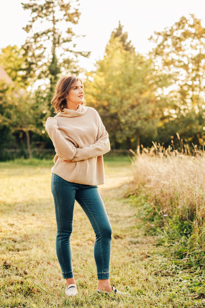 Outdoor portrait of beautiful young woman in the park, wearing warm knitted pullover - Fotoğraf, Görsel
