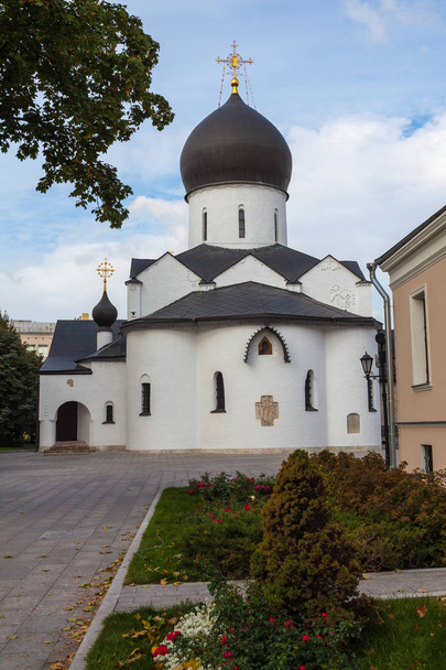 White-stone church in the Martha-Mariinsky monastery of mercy. In the foreground are flower beds with small trees - Фото, зображення