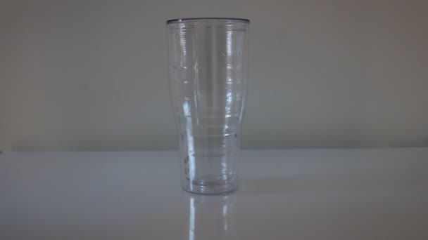 Plastik bir barista elinin plastik bir bardağa buz küpleri koyması. Bir barmen bir bar sayacı ile bir bar sayacı üzerinde duran bir paket fincan içine bir sürahi buz dökme - Video, Çekim