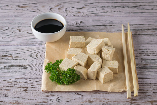 Slices of tofu cheese, soy sauce and wooden sticks. Soy cheese. - Photo, Image