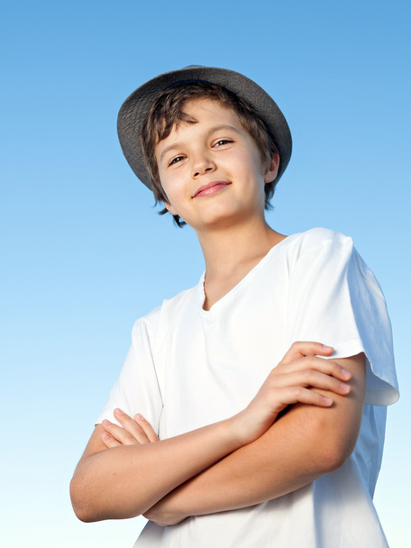 Handsome teenage boy standing outside against a blue sky - Foto, Imagen
