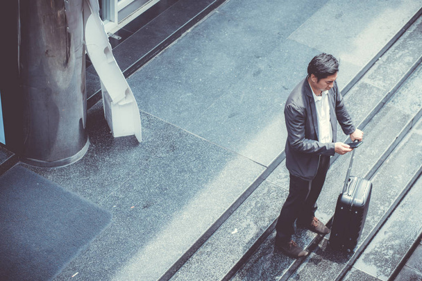 Азиатский элегантный бизнесмен носит костюм говорящего мобильного телефона, пока W
 - Фото, изображение