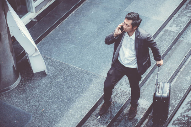 Asian elegant businessman wear suit talking mobile phone while w - Foto, imagen
