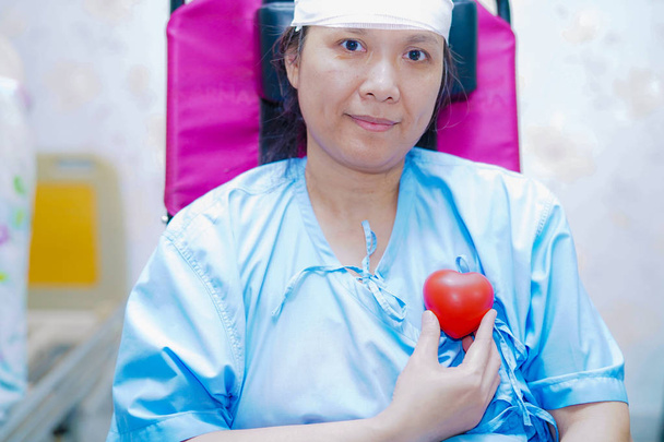 Asijské starší, či starší stará dáma žena pacient drží červené srdce v ruce na posteli v ošetřovatelské nemocniční oddělení: zdravé silné zdravotnické koncepce - Fotografie, Obrázek